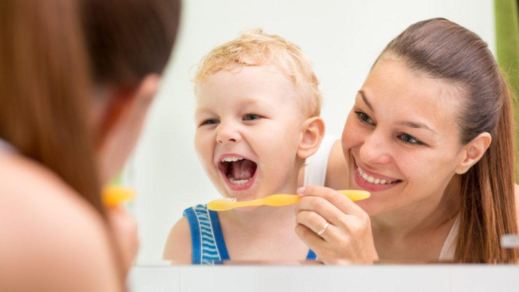 when should you first brush your childs teeth